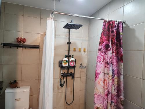 a shower in a bathroom with a shower curtain at DG CONDOTEL @MANHATTAN PLAZA T2 STUDIO WITH BALCONY , 50 INCH TV AND UNLI WIFI @Araneta Cubao Quezon City Philippines in Manila