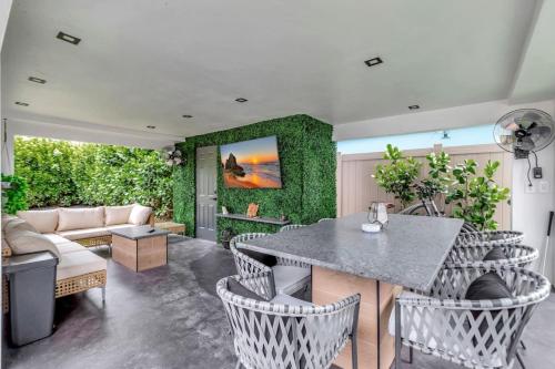 フォート・ローダーデールにあるLovely 2BR 2BA Modern Flat with Vibrant Backyardのテーブルと椅子とソファのあるリビングルーム