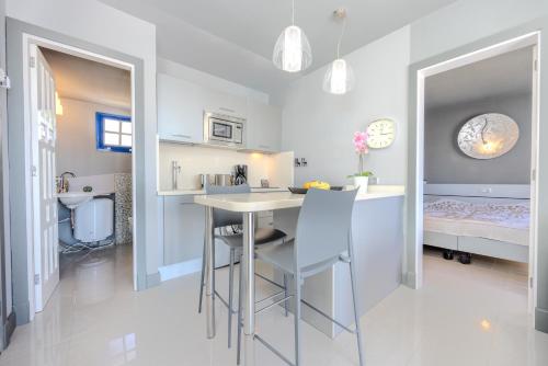 a kitchen and dining room with a table and chairs at Atalaya 2 Sea View - Puerto del Carmen in Tías