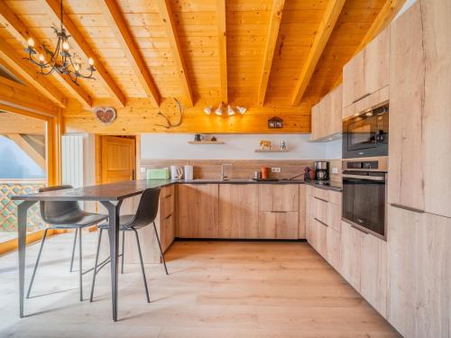 une cuisine avec des armoires en bois et une table avec des chaises dans l'établissement Grand appart 3 pièces, 8 pers, garage, wifi, La Clusaz - FR-1-437-114, à La Clusaz