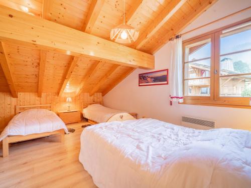 une chambre avec deux lits et un plafond en bois dans l'établissement Grand appart 3 pièces, 8 pers, garage, wifi, La Clusaz - FR-1-437-114, à La Clusaz