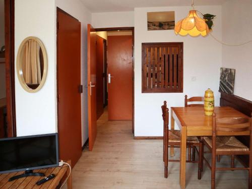 une salle à manger avec une table et une télévision dans l'établissement Studio cosy aux Orres, skis aux pieds, balcon, animaux OK - FR-1-322-641, aux Orres