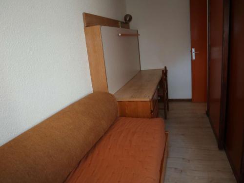 Cette chambre comprend un canapé et un réfrigérateur. dans l'établissement Studio cosy aux Orres, skis aux pieds, balcon, animaux OK - FR-1-322-641, aux Orres