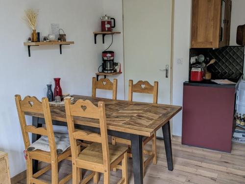 une cuisine avec une table et des chaises en bois dans l'établissement Pied des pistes, 2P, 5 pers, balcon, cuisine équipée - FR-1-557-131, à Les Adrets