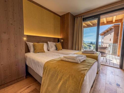 a bedroom with two beds and a large window at Appartement neuf avec terrasse, SPA et parking inclus - 6 pers - FR-1-352-103 in Arc 1800