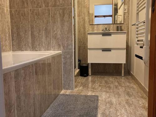 une salle de bain avec un lavabo et une baignoire dans l'établissement Appartement Centre-Ville avec Parking - 4 à 6 pers, Cauterets - FR-1-234-326, à Cauterets