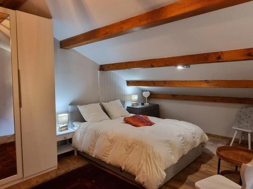 une chambre avec un lit blanc et des plafonds en bois dans l'établissement Duplex lumineux 6/7 pers, accès pistes, WIFI, animaux acceptés - FR-1-181-2836, à La Plagne Tarentaise