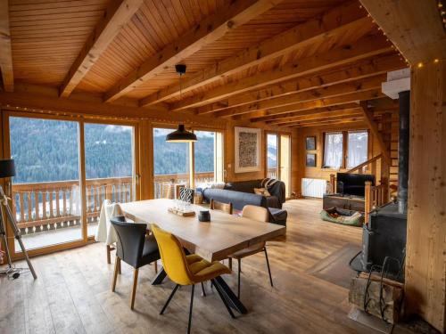 une salle à manger et un salon avec une table et des chaises dans l'établissement Chalet spacieux 12 pers, 4 ch, 4 sdb, cuisine équipée, parking, cheminée - FR-1-676-201, à La Chapelle-dʼAbondance