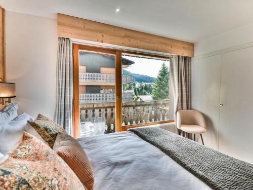 une chambre avec un lit et une grande fenêtre dans l'établissement Confort aux Gets: T2 avec balcons, ski et parking - FR-1-685-83, aux Gets