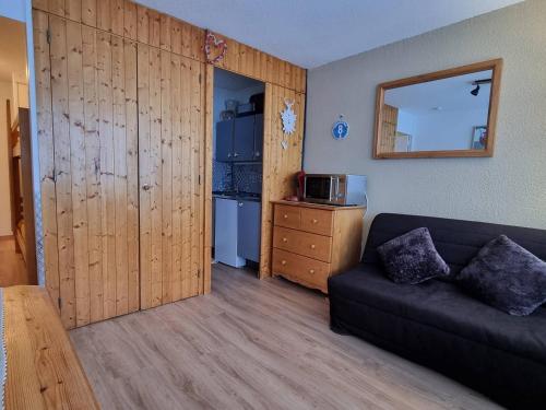 un salon avec un canapé et une cuisine dans l'établissement Appartement cosy à 100m des pistes, terrasse sud - FR-1-351-224, à La Plagne Tarentaise