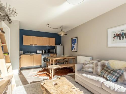 un salon avec un canapé et une cuisine dans l'établissement Charmant T3 avec balcon, proche pistes, parking inclus - FR-1-351-235, à La Plagne Tarentaise