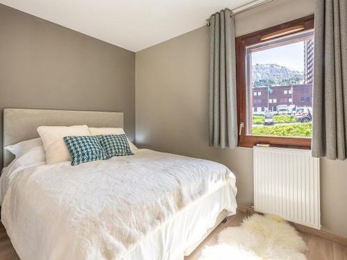 une chambre avec un lit blanc et une fenêtre dans l'établissement Charmant T3 avec balcon, proche pistes, parking inclus - FR-1-351-235, à La Plagne Tarentaise