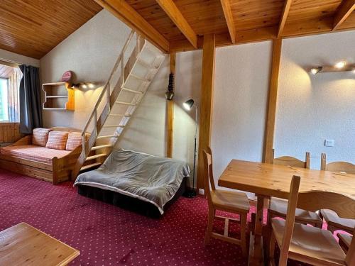 une chambre avec un escalier, une table et un lit dans l'établissement Appartement confortable avec mezzanine, terrasse et casier à ski aux pieds des pistes - FR-1-351-236, à La Plagne Tarentaise