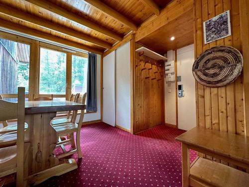 une chambre avec une table et des chaises dans une cabine dans l'établissement Appartement confortable avec mezzanine, terrasse et casier à ski aux pieds des pistes - FR-1-351-236, à La Plagne Tarentaise