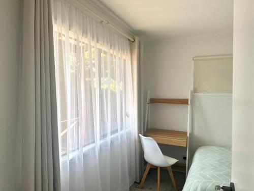 a bedroom with a window with a chair and a bed at Private room with separate bathroom and carpark in Auckland