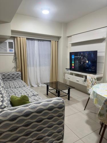 a living room with a couch and a flat screen tv at Jojies Crib Horizons101 2bedrooms in Cebu City