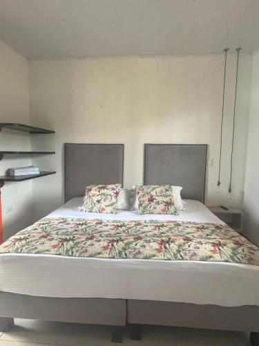 a bedroom with a large bed with flowers on it at Hotel Terra Tacuara in Armenia