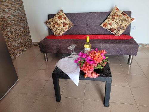 a table with a bottle of wine and flowers on a couch at Cabañas y Restaurante Miss Elma in Providencia