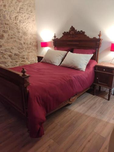 - une chambre avec un grand lit rouge et 2 tables de chevet dans l'établissement Gîte des 4 saisons, à Saint-Lazare