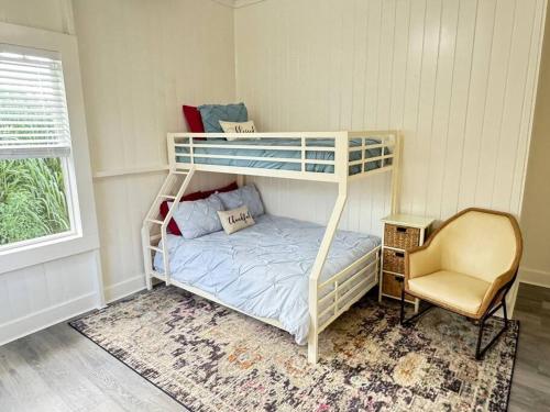 a bedroom with a bunk bed and a chair at YOUR PERFECT HILO HOMEBASE - Sleeps 10 with AC, WD, BBQ in Hilo