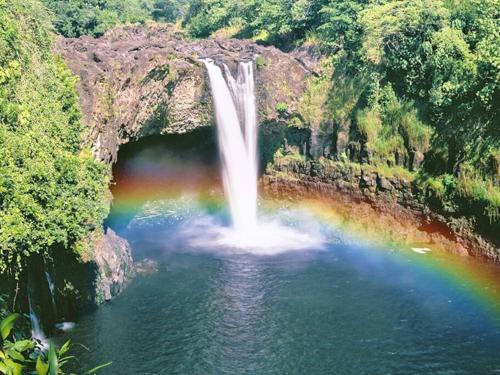 a rainbow in the water next to a waterfall at YOUR PERFECT HILO HOMEBASE - Sleeps 10 with AC, WD, BBQ in Hilo