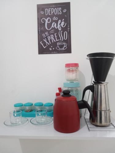 a kitchen counter with a coffee maker and some cups at Loft4 COMPLETO AR CANAIS ASSINAT GARAGEM INTERNET prox Aparecida e Industrias in Pindamonhangaba