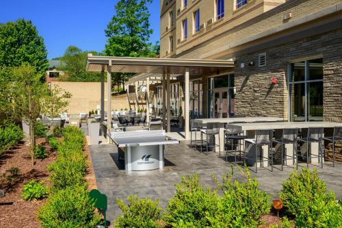 a patio with tables and chairs outside of a building at Courtyard by Marriott Raleigh Cary Crossroads in Cary