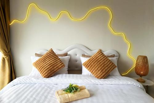 a bedroom with a white bed with wicker pillows at Panoramic Condo 50 sqm Karon in Karon Beach