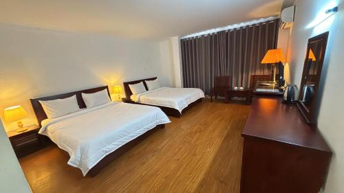 Postel nebo postele na pokoji v ubytování Phung Long Hotel