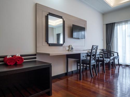 a dining room with a table and chairs and a mirror at Grand Jomtien Palace Hotel - SHA Extra Plus in Jomtien Beach