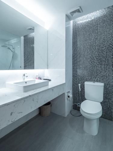 a white bathroom with a toilet and a sink at Grand Jomtien Palace Hotel - SHA Extra Plus in Jomtien Beach