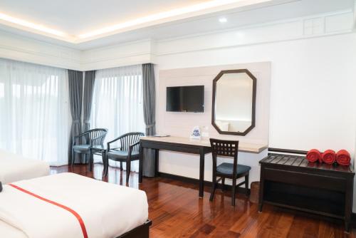 a hotel room with a desk and a mirror at Grand Jomtien Palace Hotel - SHA Extra Plus in Jomtien Beach