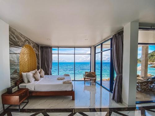 a bedroom with a bed and a view of the ocean at P.D. Beach Resort in Ko Tao