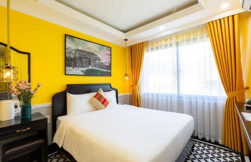 una camera gialla con letto e finestra di THE 1903 Sapa a Sa Pa