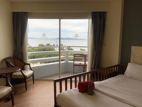 a bedroom with a bed and a view of the ocean at Grand Jomtien Palace Hotel - SHA Extra Plus in Jomtien Beach