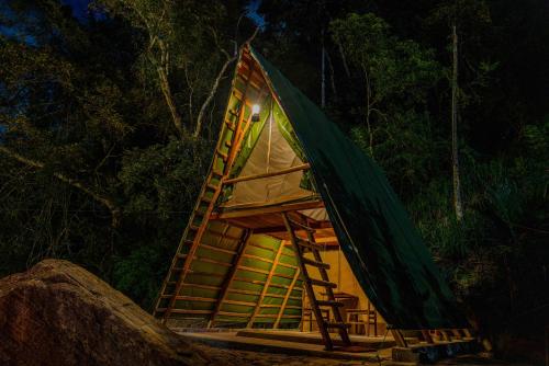 a tree house with a ladder and a tent at Bambara Ella Agro Resort & Camping in Haputale