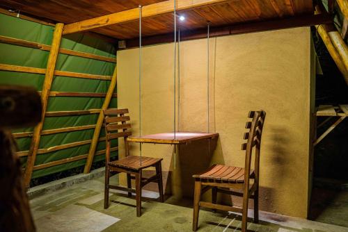 two chairs and a table in a room at Bambara Ella Agro Resort & Camping in Haputale