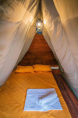 a bed in a tent with a light on it at Bambara Ella Agro Resort & Camping in Haputale