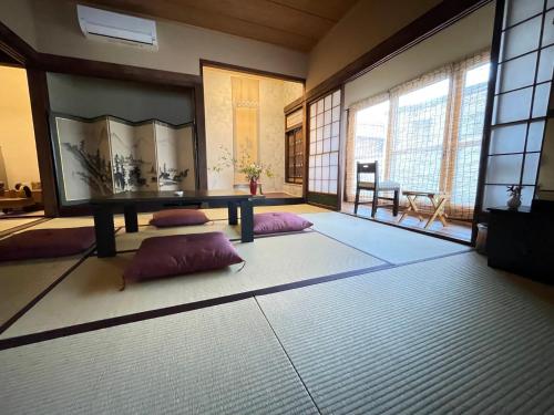 a room with a table and two pillows on the floor at Aioi Yanto 一日一組限定古民家宿 in Otaru