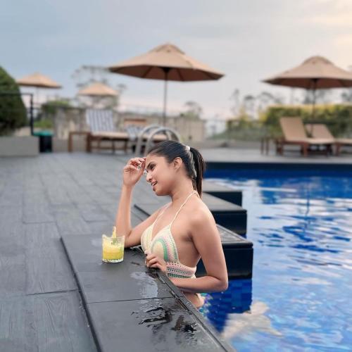 a woman sitting in a swimming pool with a drink at The Argyle Luxury Boutique in Hatton