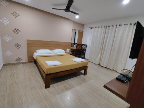 a bedroom with a bed and a flat screen tv at Nandan Residency in Mysore