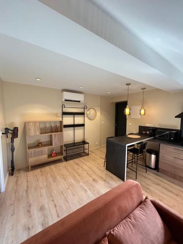 un salon avec un canapé et une cuisine dans l'établissement Maison à la campagne, à Bons-Tassily