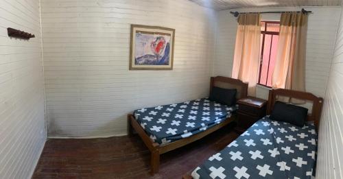 a small room with two beds and a window at Casa de Campo vista para o Lago em Juquitiba SP in Juquitiba