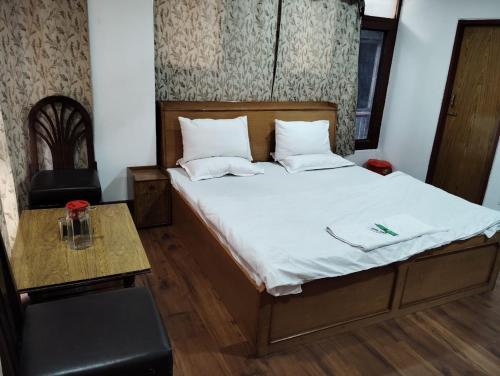 a bed in a room with a table and a bed sidx sidx sidx at Hotel Ruby and Restaurant in Srinagar