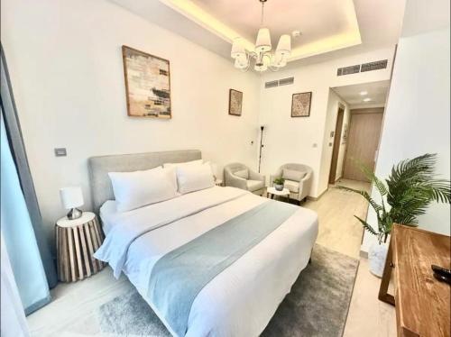 a bedroom with a large bed and a chandelier at Dubai Galaxy in Azizi Riviera Luxury Studio in Dubai