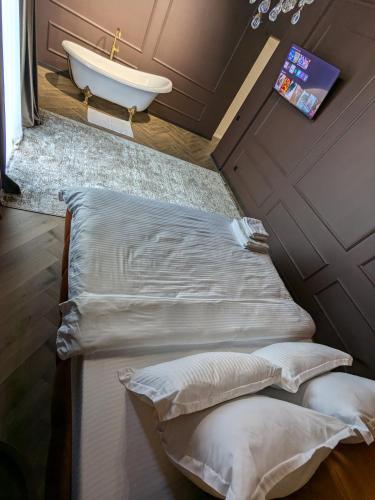 a bathroom with a bed and a sink and a tub at Park Gate apartment in Chernivtsi
