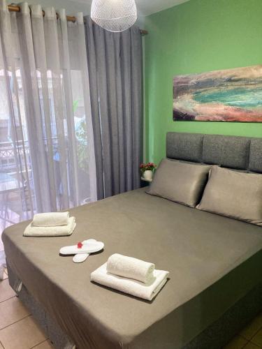 a bedroom with a large bed with green walls at M.O.M.’s in Alexandroupoli