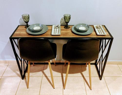 a table with two chairs and plates and wine glasses at M.O.M.’s in Alexandroupoli