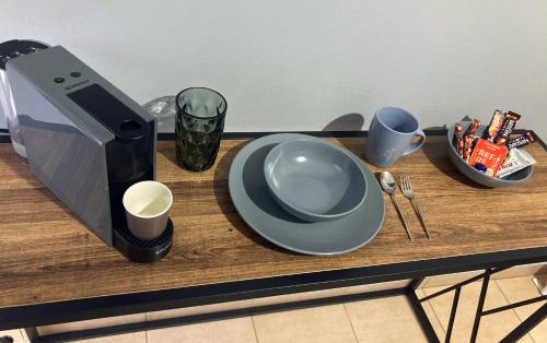 a table with a plate and a coffee maker and cups at M.O.M.’s in Alexandroupoli