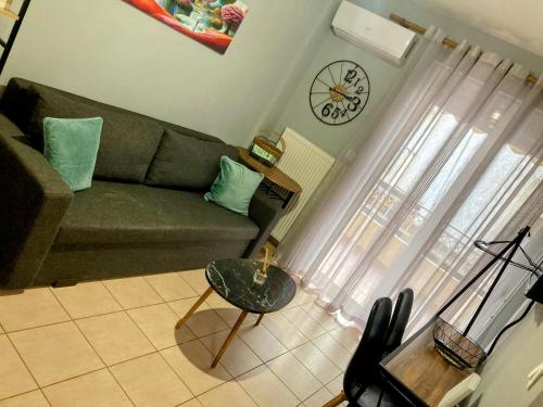 a living room with a couch and a clock on the wall at M.O.M.’s in Alexandroupoli